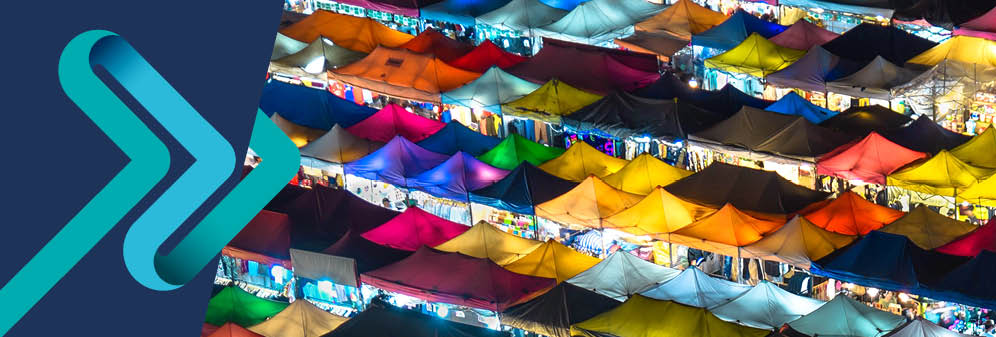 Multi-coloured tops of stalls viewed from above, lit up as it is a night time scene.